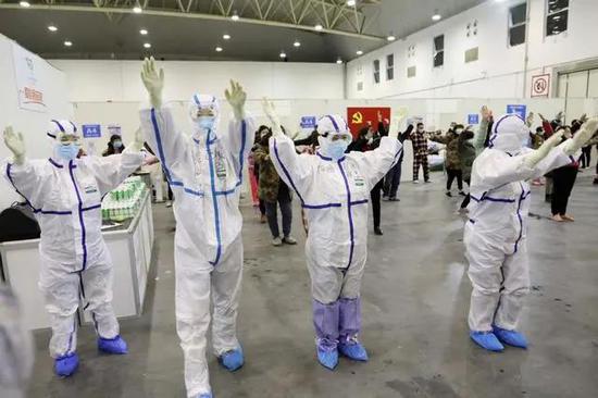 医务人员与患者在武汉客厅方舱医院病房内  做广播体操（中国日报记者 朱兴鑫 摄）